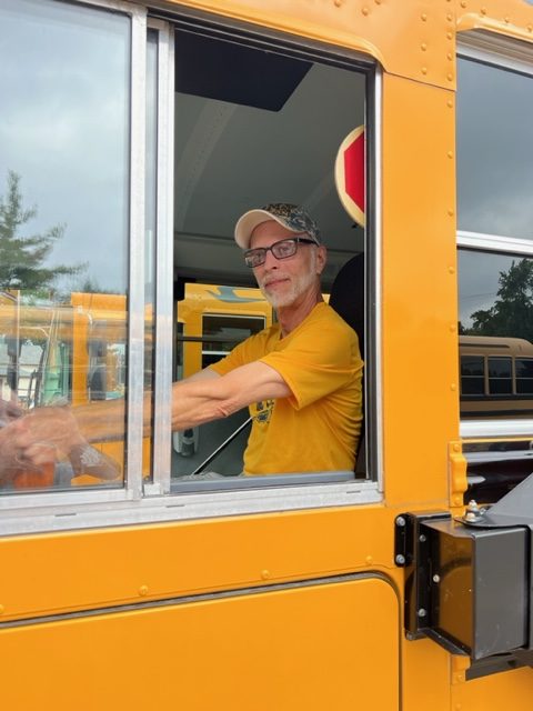 male bus driver sitting at the wheel of a bus